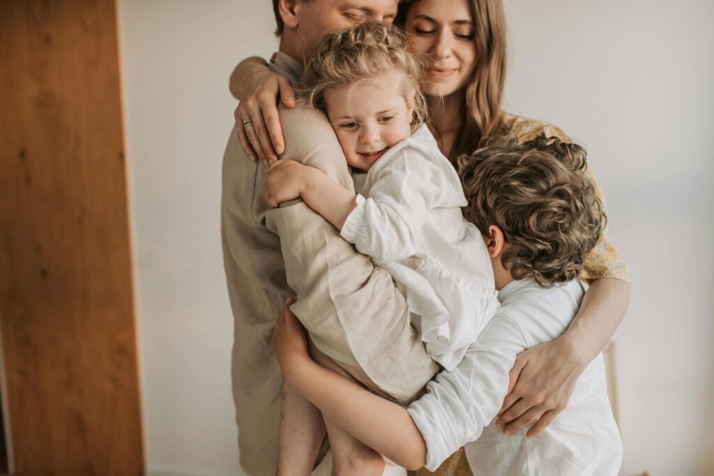 A loving family embraces, showcasing warmth and connection in a cozy indoor environment.